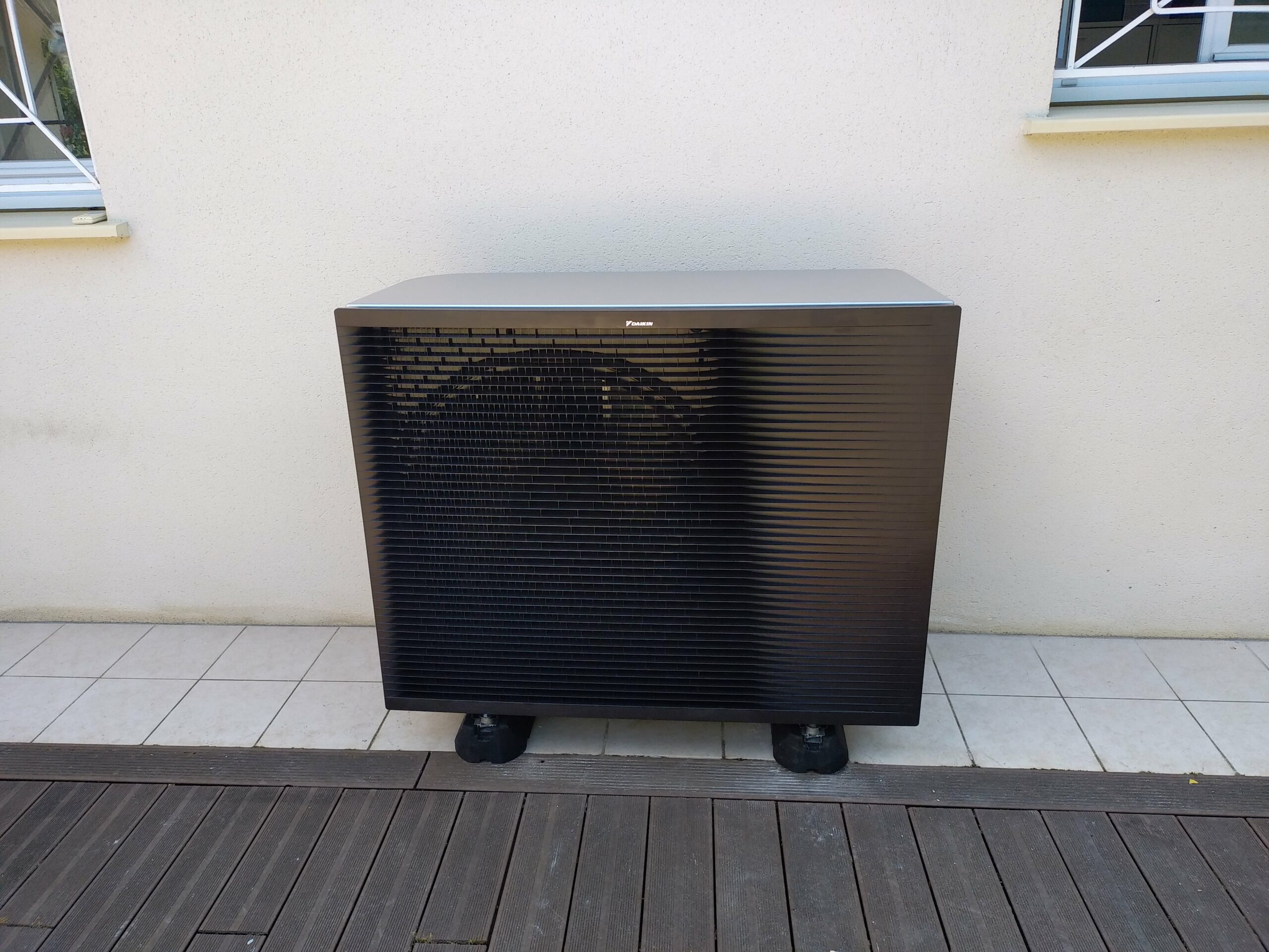 Unité extérieure de pompe à chaleur Daikin avec cache Decoclim blanc installée à Mérignac par Froid Climatisation System